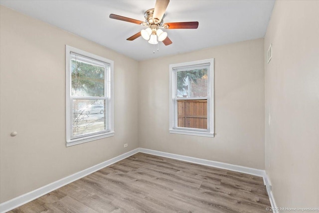 empty room with a ceiling fan, baseboards, and wood finished floors