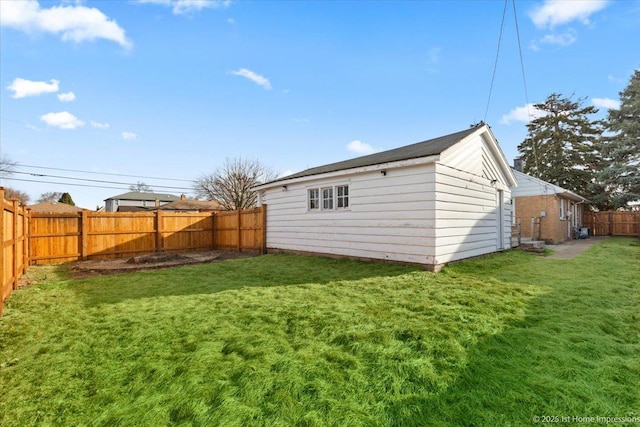 rear view of house with a lawn and a fenced backyard