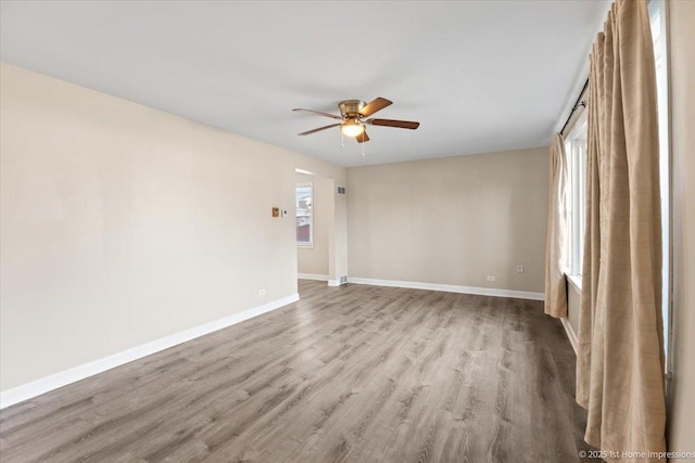 spare room with wood finished floors, baseboards, and ceiling fan