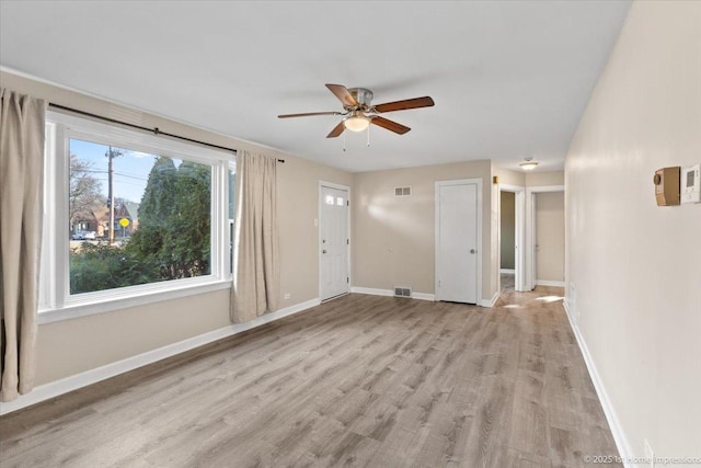 interior space with visible vents, baseboards, ceiling fan, and light wood finished floors