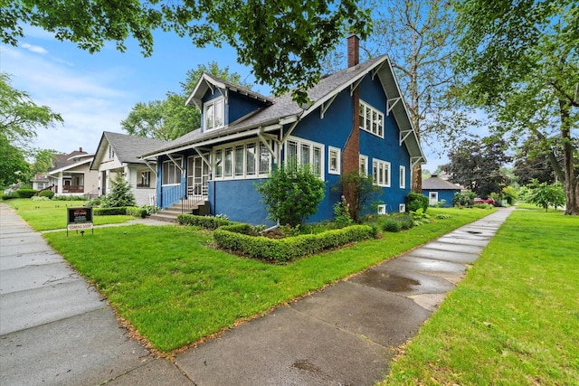 896 S Myrtle Ave, Kankakee, IL 60901 - view of front of property featuring a chimney, a front yard, stucco siding, and a shingled roof