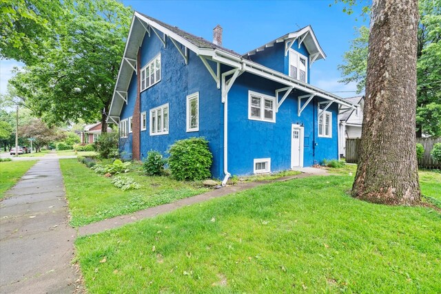 896 S Myrtle Ave, Kankakee, IL 60901 - view of home's exterior with stucco siding, a chimney, and a lawn