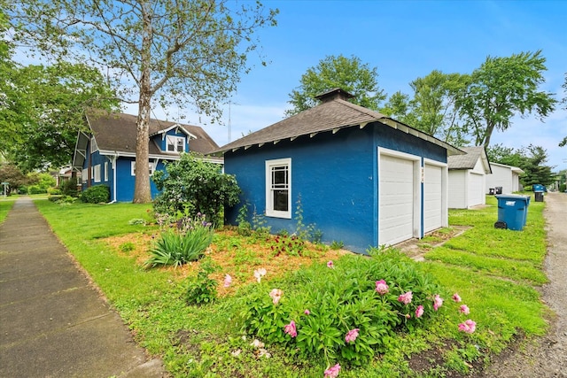 896 S Myrtle Ave, Kankakee, IL 60901 - view of property exterior featuring stucco siding, a garage, and a shingled roof