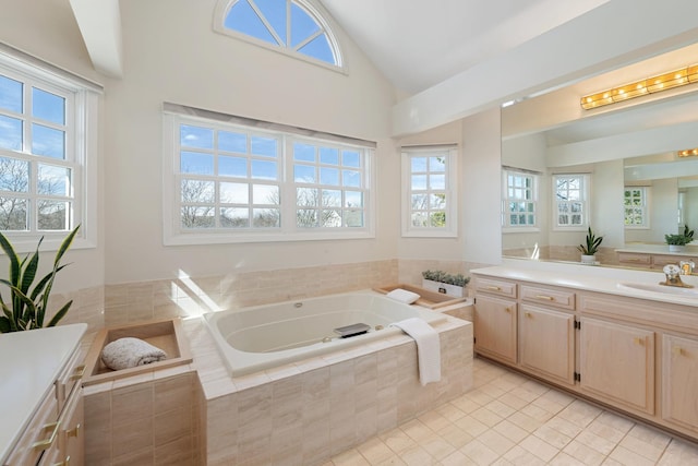 bathroom featuring vanity, lofted ceiling, a bath, and tile patterned floors