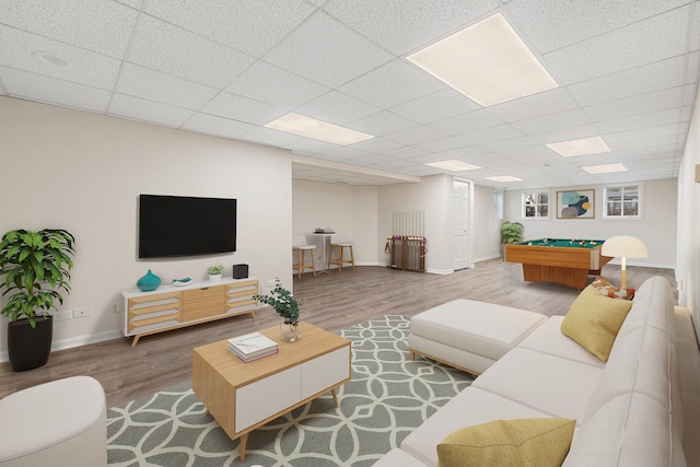 living room featuring a drop ceiling, billiards, baseboards, and wood finished floors