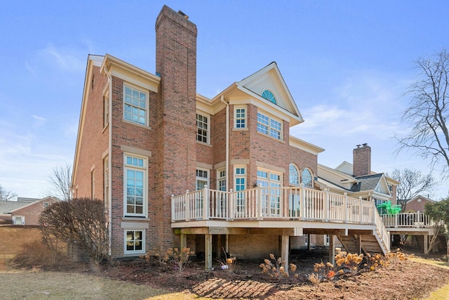 back of house with a wooden deck, stairway, brick siding, and a chimney