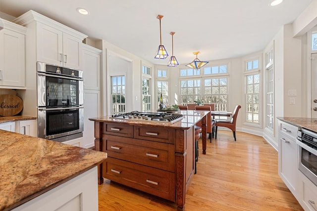 kitchen with light wood-style flooring, white cabinetry, recessed lighting, stainless steel appliances, and a healthy amount of sunlight