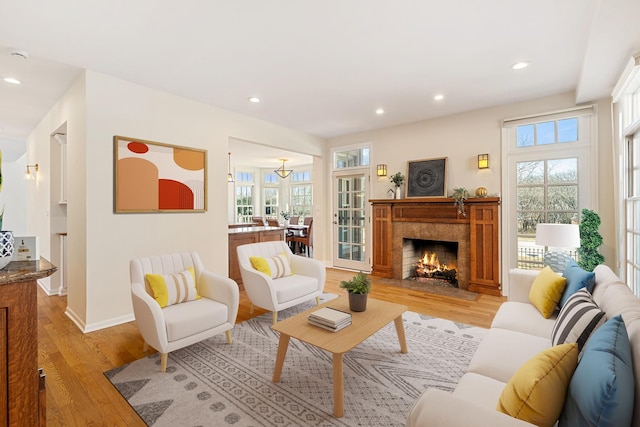 living room with a wealth of natural light, recessed lighting, light wood-style flooring, and baseboards