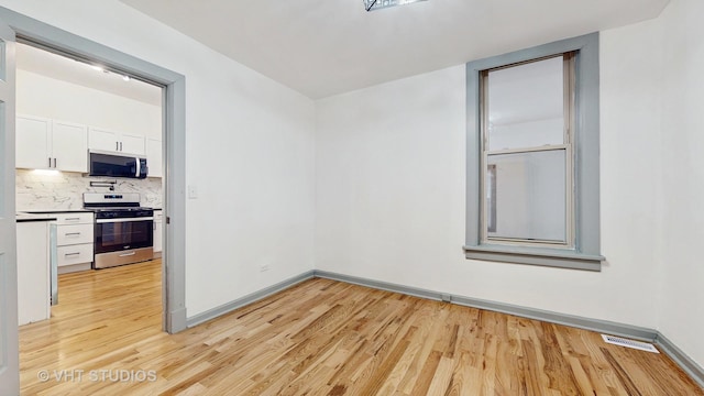 unfurnished room with visible vents, baseboards, and light wood-style flooring