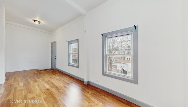 empty room featuring baseboards and light wood-style flooring