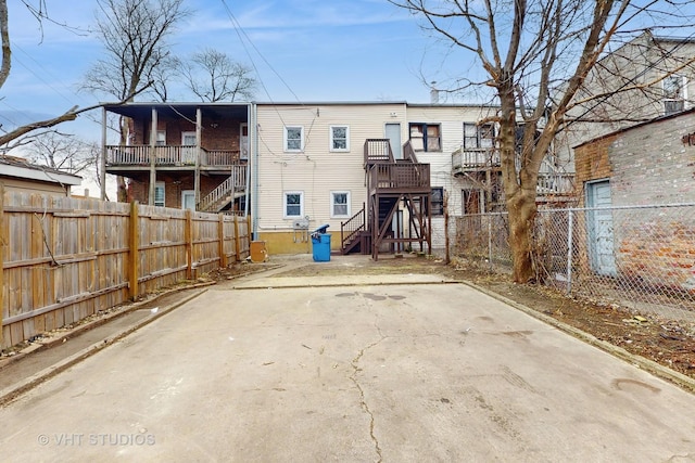 rear view of property with stairs and fence