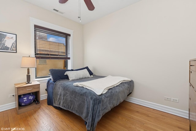 bedroom with visible vents, baseboards, hardwood / wood-style floors, and a ceiling fan