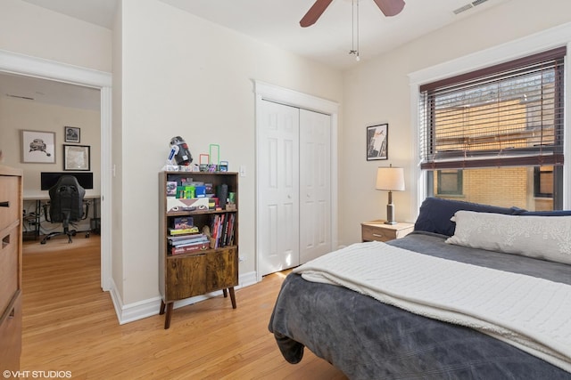 bedroom with a ceiling fan, visible vents, baseboards, light wood-style flooring, and a closet