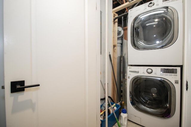 clothes washing area with stacked washer / dryer and laundry area