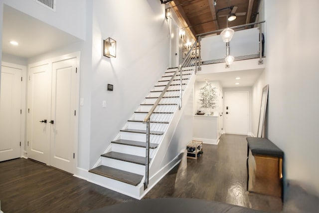 stairway with visible vents, baseboards, and wood finished floors