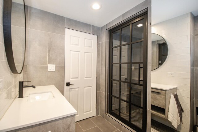 full bath featuring tile patterned flooring, tile walls, and vanity