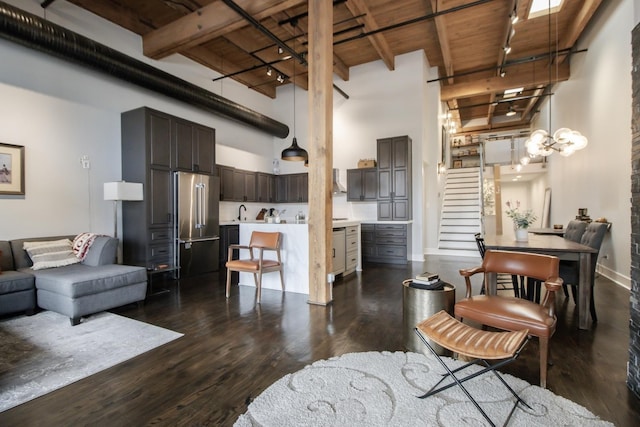 living area with stairway, rail lighting, a high ceiling, and dark wood-type flooring