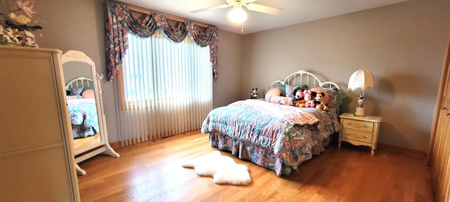 bedroom featuring baseboards, ceiling fan, and wood finished floors