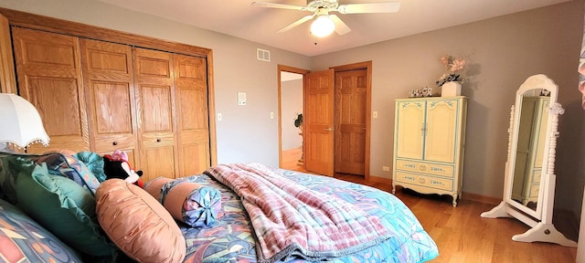 bedroom featuring light wood finished floors, visible vents, baseboards, and ceiling fan