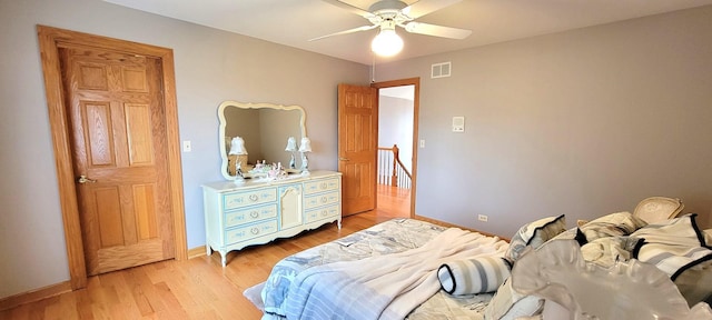 bedroom with a ceiling fan, baseboards, visible vents, and light wood-type flooring