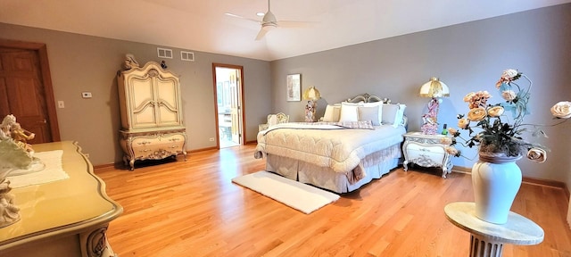 bedroom with light wood finished floors, visible vents, and baseboards