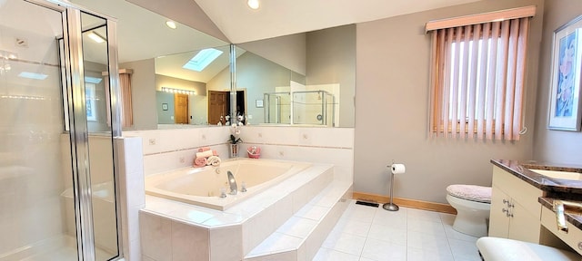 bathroom with a garden tub, toilet, a stall shower, vaulted ceiling with skylight, and vanity