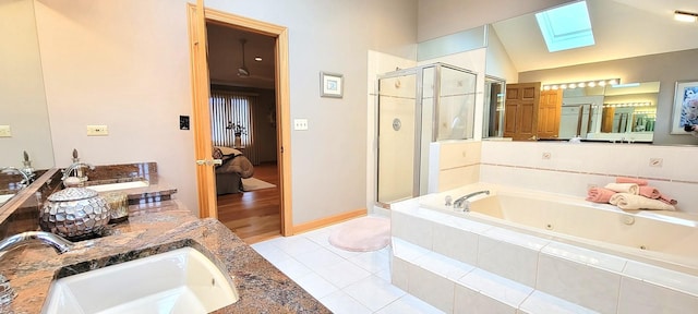 ensuite bathroom featuring tile patterned floors, ensuite bathroom, a jetted tub, vaulted ceiling with skylight, and a shower stall