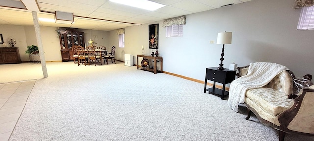 living area featuring visible vents, a paneled ceiling, baseboards, and carpet flooring