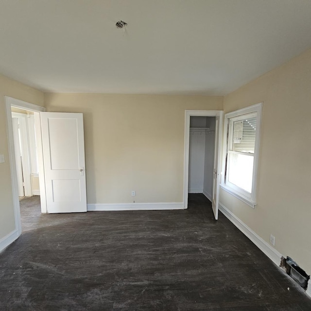 spare room featuring baseboards and dark wood-style flooring