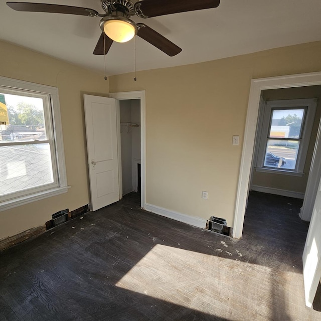 unfurnished bedroom with wood finished floors, baseboards, and ceiling fan