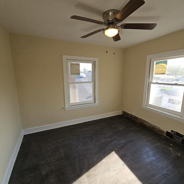 spare room with baseboards and dark wood-type flooring