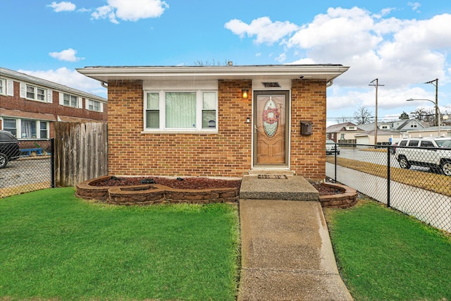 bungalow featuring a front lawn, fence, and brick siding