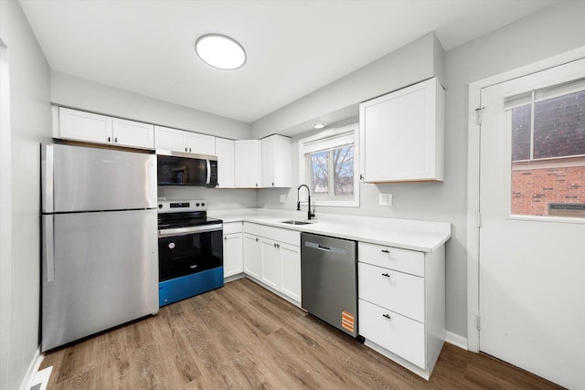 2077 Lioncrest Dr, Richton Park, IL 60471 - kitchen with white cabinetry, appliances with stainless steel finishes, wood finished floors, and a sink