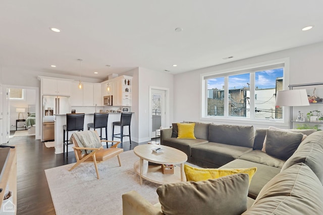 living area with recessed lighting, visible vents, baseboards, and dark wood finished floors