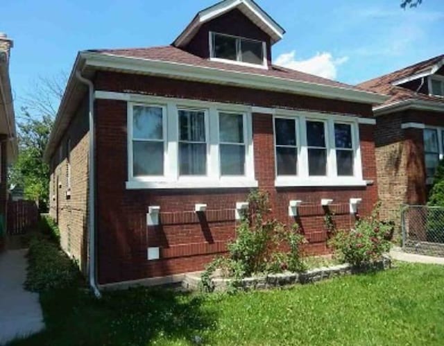 view of side of property with fence and brick siding