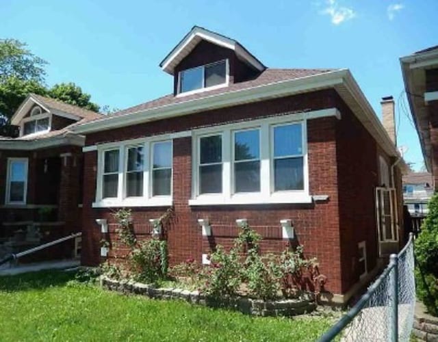 view of home's exterior featuring brick siding and fence