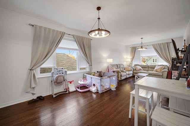 living area with wood finished floors, baseboards, and a healthy amount of sunlight