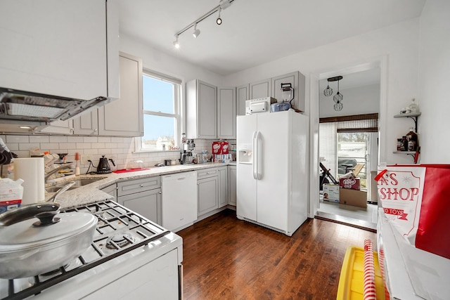 kitchen featuring white appliances, dark wood-style floors, a healthy amount of sunlight, and tasteful backsplash