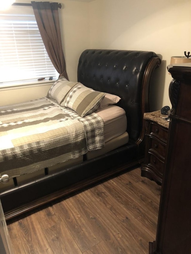 bedroom with dark wood-style flooring