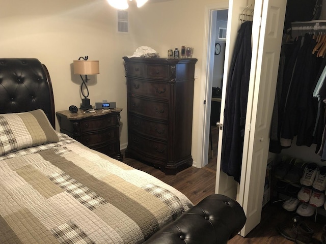 bedroom with a closet, visible vents, and wood finished floors