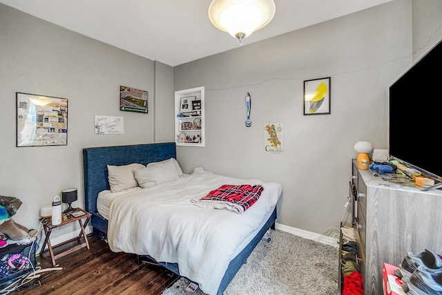 bedroom featuring baseboards and wood finished floors