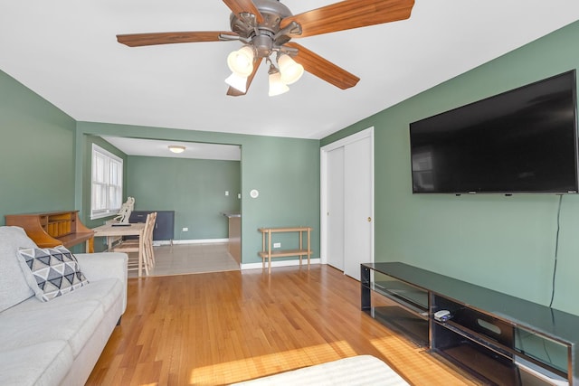 living room with a ceiling fan, wood finished floors, and baseboards