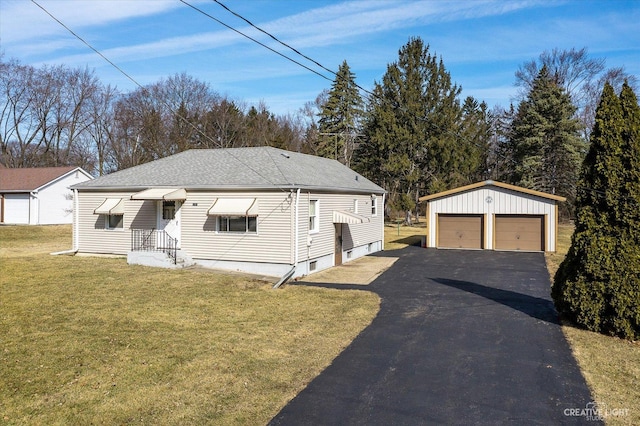 view of front facade featuring a detached garage, an outbuilding, a front lawn, and a shingled roof