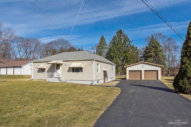 view of front of property featuring a garage, roof with shingles, an outdoor structure, and a front yard