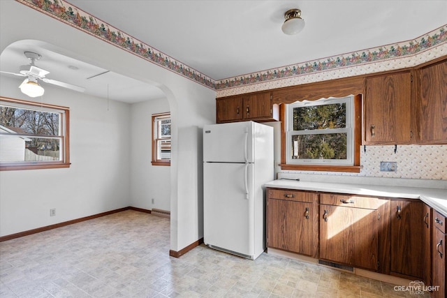 kitchen featuring a wealth of natural light, light countertops, and freestanding refrigerator