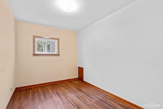 unfurnished room featuring baseboards and wood finished floors