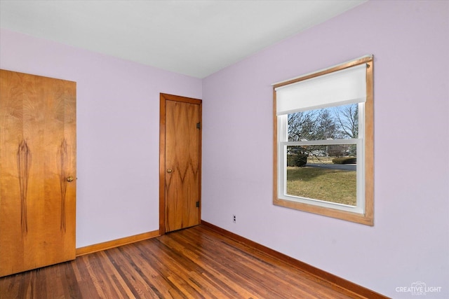 unfurnished bedroom featuring dark wood finished floors and baseboards