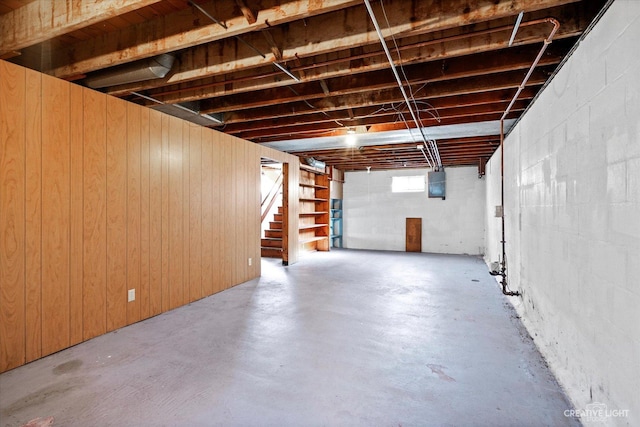 basement featuring stairway and electric panel