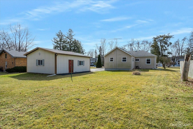 back of house featuring an outbuilding and a lawn