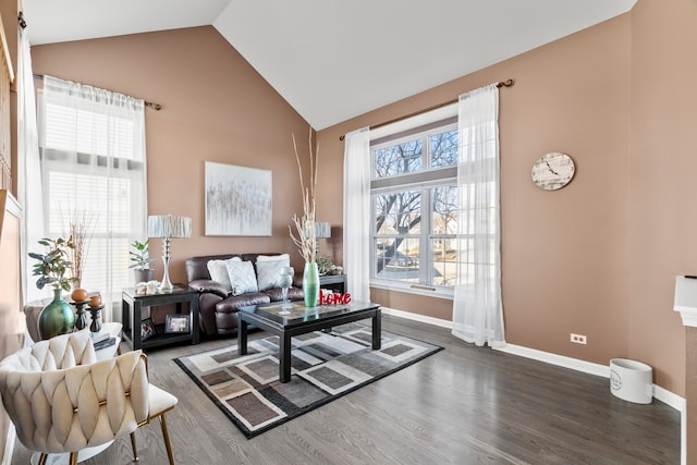 living area featuring baseboards, plenty of natural light, wood finished floors, and vaulted ceiling